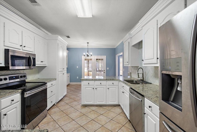 kitchen featuring white cabinets, decorative light fixtures, stainless steel appliances, and sink