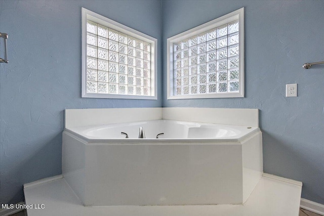 bathroom with a washtub and a healthy amount of sunlight