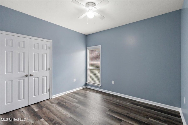 unfurnished bedroom with ceiling fan, dark wood-type flooring, and a closet