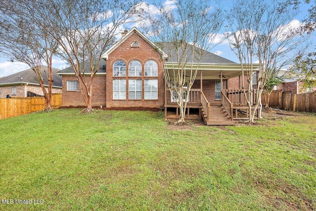 back of property with a lawn and a deck