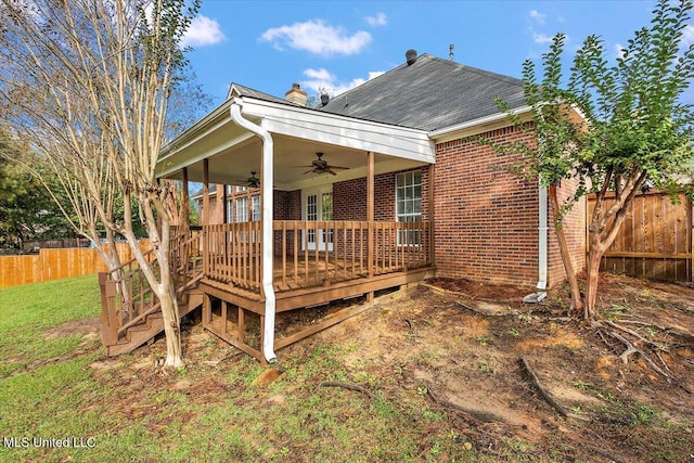 back of house featuring a lawn, ceiling fan, and a deck