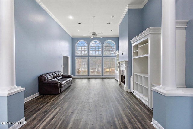 unfurnished room featuring decorative columns, ceiling fan, dark hardwood / wood-style flooring, and crown molding