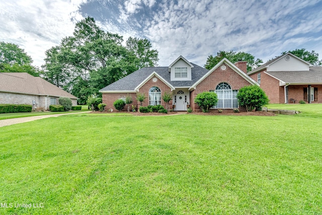 708 Oak Trl, Canton, MS 39046 - traditional-style house with brick siding, a front yard, and a shingled roof