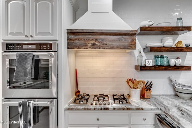 708 Oak Trl, Canton, MS 39046 - kitchen featuring appliances with stainless steel finishes, tasteful backsplash, white cabinets, light stone counters, and open shelves