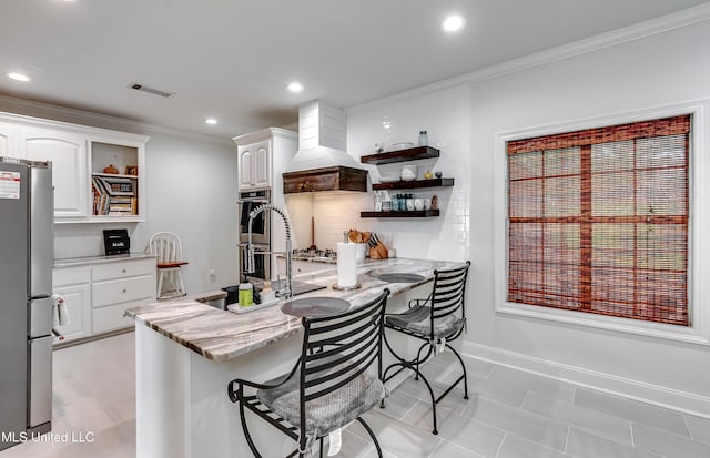 708 Oak Trl, Canton, MS 39046 - kitchen featuring open shelves, stainless steel appliances, custom exhaust hood, white cabinets, and ornamental molding