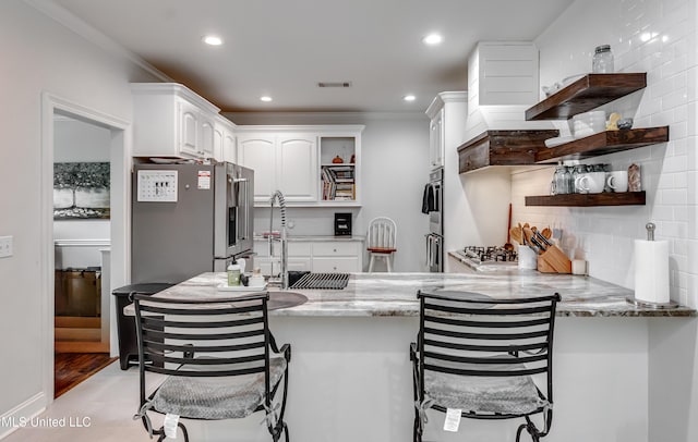 708 Oak Trl, Canton, MS 39046 - kitchen with open shelves, a sink, a peninsula, white cabinets, and tasteful backsplash