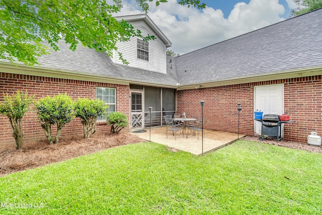 708 Oak Trl, Canton, MS 39046 - back of property featuring roof with shingles, a yard, a patio area, and brick siding