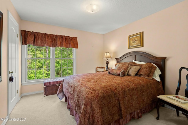bedroom featuring baseboards and light carpet