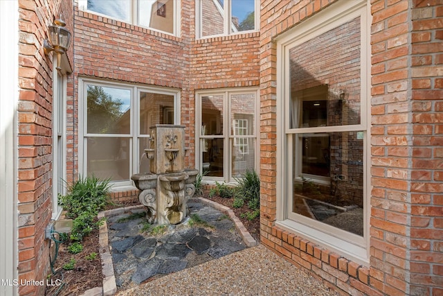 view of exterior entry with brick siding
