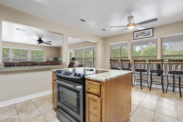 5297 Tuxachanie Dr, Biloxi, MS 39532 - kitchen with stainless steel electric range oven, a ceiling fan, light tile patterned floors, and open floor plan