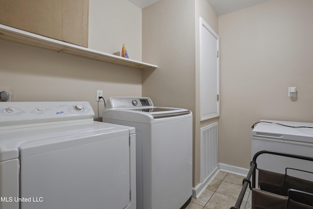 5297 Tuxachanie Dr, Biloxi, MS 39532 - laundry room with washing machine and clothes dryer, light tile patterned flooring, and baseboards