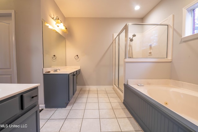 bathroom featuring tile patterned floors, vanity, a shower stall, baseboards, and a tub with jets