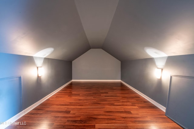 bonus room with vaulted ceiling, wood finished floors, and baseboards