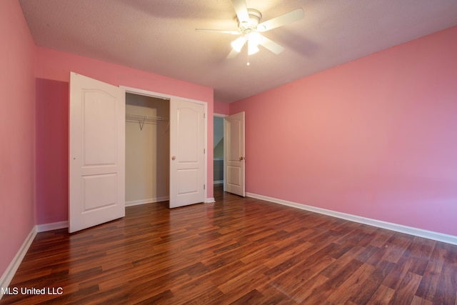 unfurnished bedroom featuring ceiling fan, dark wood-type flooring, a closet, and baseboards