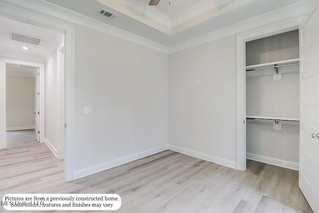 unfurnished bedroom featuring a closet, wood finished floors, and visible vents