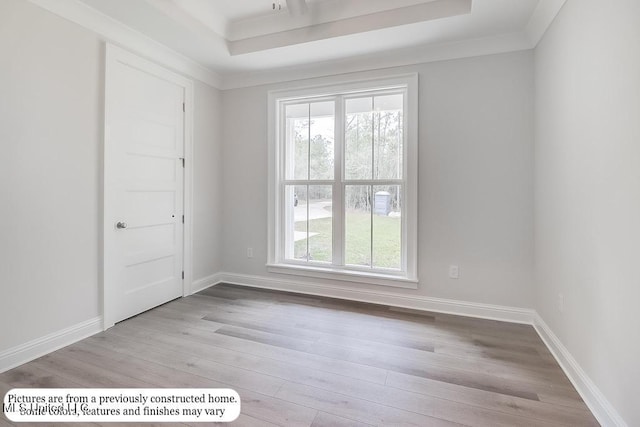 empty room featuring baseboards, ornamental molding, and wood finished floors