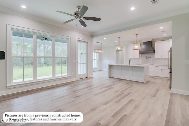 unfurnished living room featuring recessed lighting, a ceiling fan, light wood-style flooring, and a sink