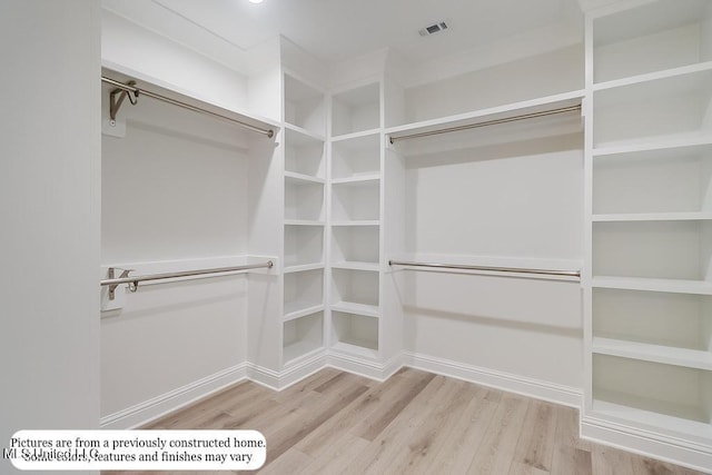 spacious closet featuring visible vents and wood finished floors
