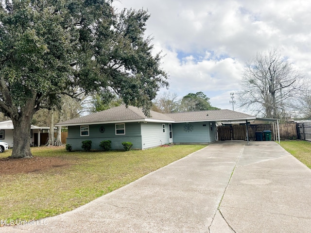 ranch-style home featuring brick siding, concrete driveway, a front lawn, and fence