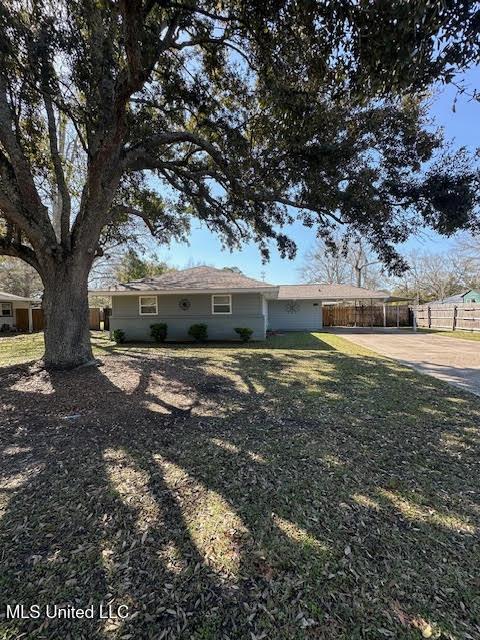 exterior space featuring driveway and fence