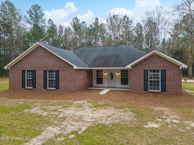 ranch-style home featuring brick siding and roof with shingles