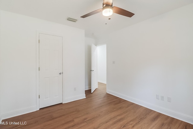 unfurnished bedroom featuring visible vents, ceiling fan, baseboards, and wood finished floors