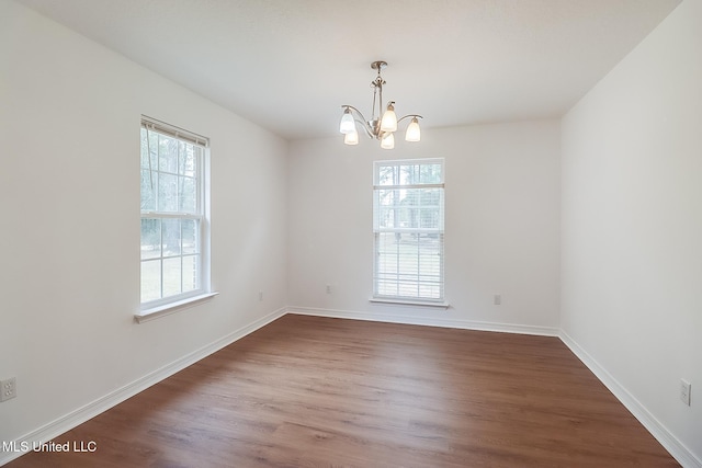 unfurnished room featuring plenty of natural light, baseboards, and dark wood-type flooring