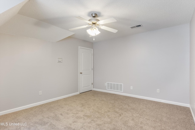 carpeted spare room featuring a textured ceiling and ceiling fan