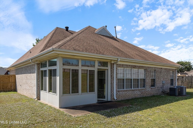 back of house featuring a yard and a sunroom