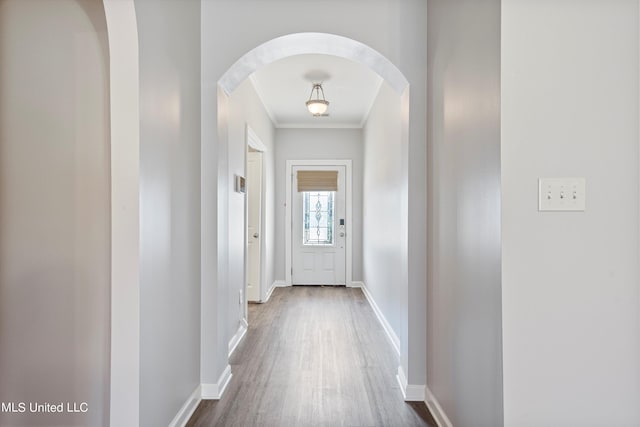 doorway with crown molding and hardwood / wood-style floors