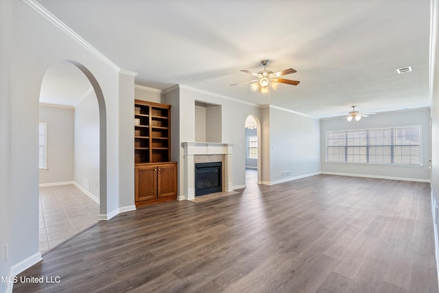 unfurnished living room featuring ceiling fan, crown molding, and dark hardwood / wood-style flooring