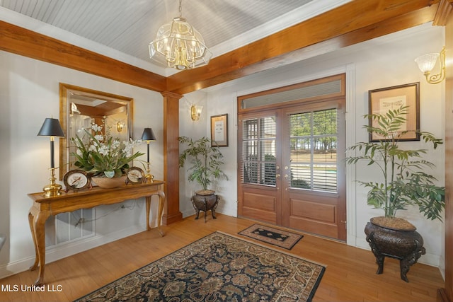 foyer entrance with wood-type flooring, french doors, and an inviting chandelier