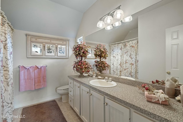 bathroom with tile patterned floors, toilet, vanity, and vaulted ceiling