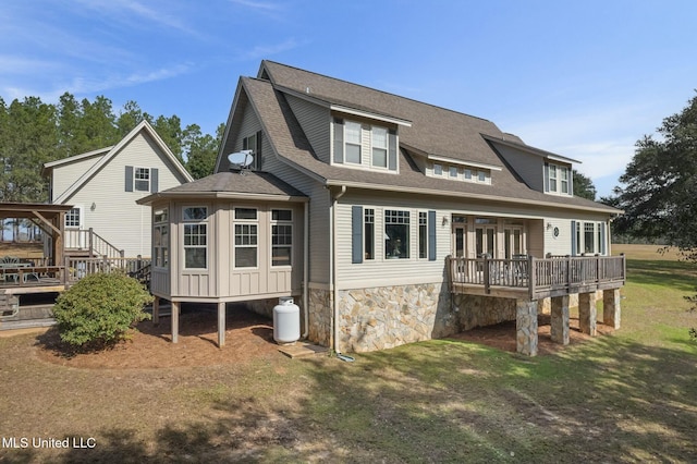 rear view of house featuring a deck and a lawn