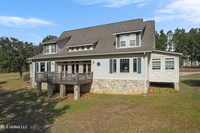 rear view of house with a deck and a yard