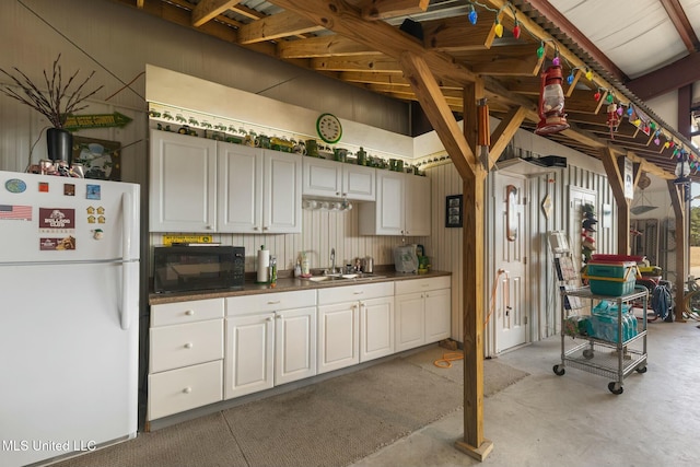 kitchen with sink, white cabinetry, and white fridge