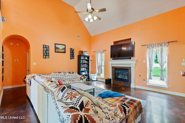 6308 Skyler Rd, Walls, MS 38680 - living area featuring high vaulted ceiling, concrete floors, ceiling fan, a fireplace, and arched walkways
