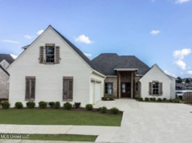 view of front of property featuring a front lawn and a garage