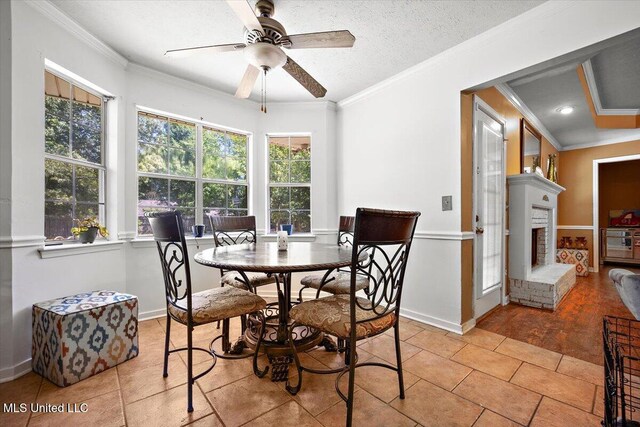 505 Golden Eagle Dr, Byram, MS 39272 - dining area featuring crown molding, a ceiling fan, a fireplace, and light tile patterned flooring