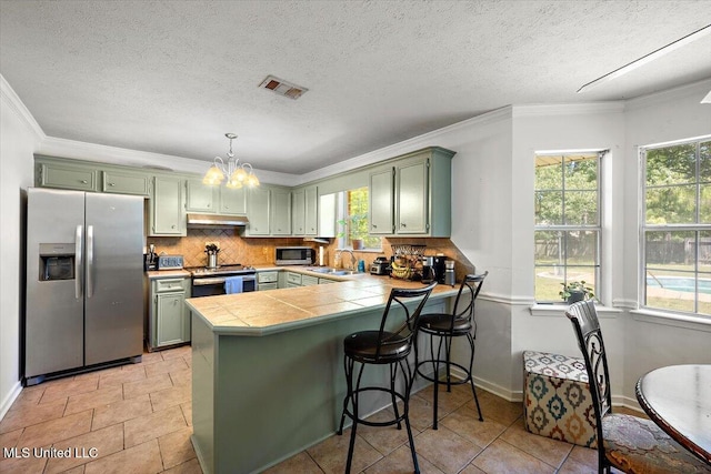 505 Golden Eagle Dr, Byram, MS 39272 - kitchen with appliances with stainless steel finishes, green cabinets, under cabinet range hood, a peninsula, and crown molding