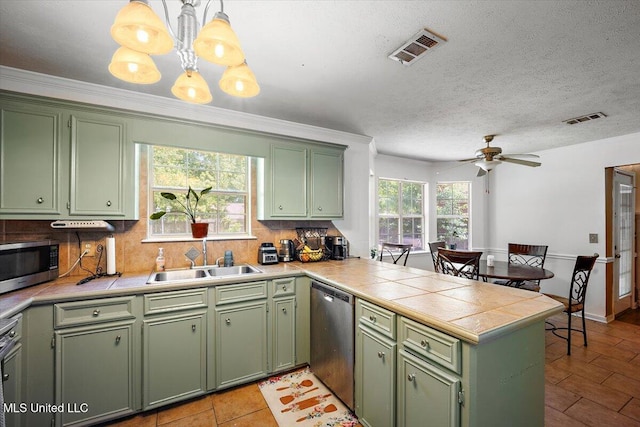 505 Golden Eagle Dr, Byram, MS 39272 - kitchen featuring green cabinets, appliances with stainless steel finishes, a peninsula, and a textured ceiling