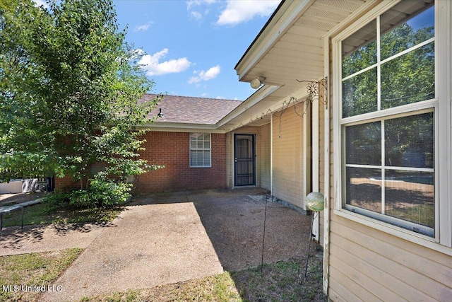 505 Golden Eagle Dr, Byram, MS 39272 - doorway to property with brick siding, roof with shingles, and a patio