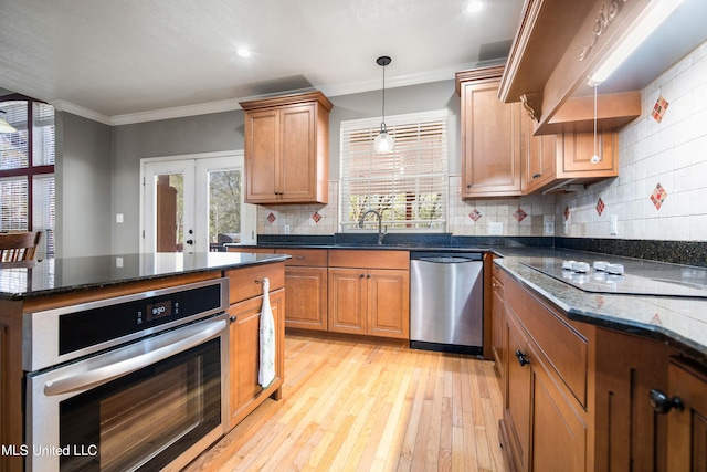 kitchen with decorative backsplash, dark stone countertops, appliances with stainless steel finishes, and french doors