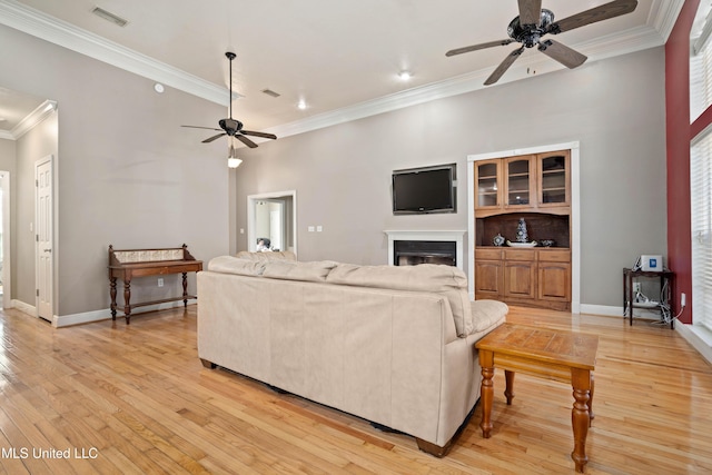 living room with ceiling fan, light hardwood / wood-style floors, and ornamental molding