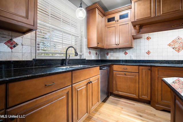 kitchen with dishwasher, sink, dark stone countertops, tasteful backsplash, and decorative light fixtures