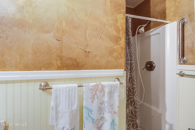 full bathroom featuring wainscoting and a shower with shower curtain