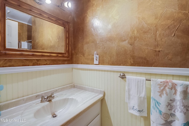 bathroom with a wainscoted wall and vanity