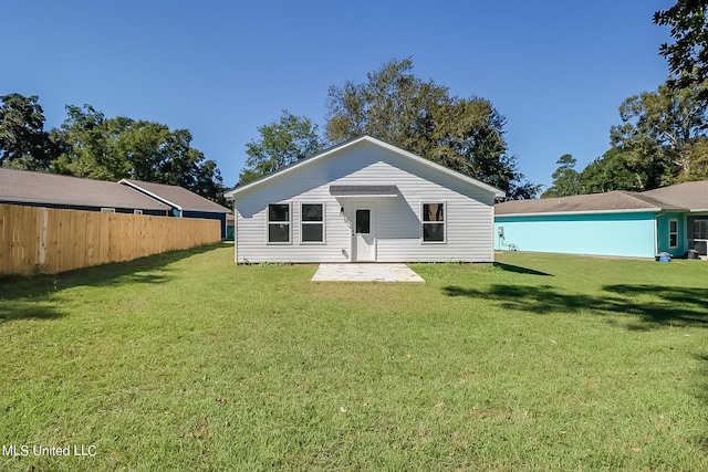 rear view of property featuring a lawn and a patio area