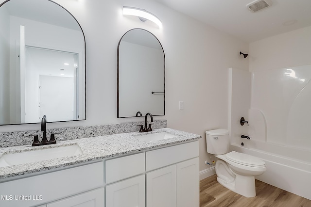 full bathroom with hardwood / wood-style floors, vanity, toilet, and tub / shower combination