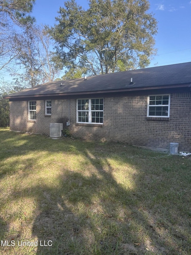 rear view of house with a yard and central AC unit